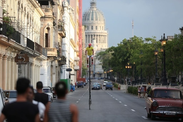 Một người đàn ông đi trên chiếc xe đạp siêu cao tự chế giữa thủ đô Havana, Cuba. Ảnh: Reuters.