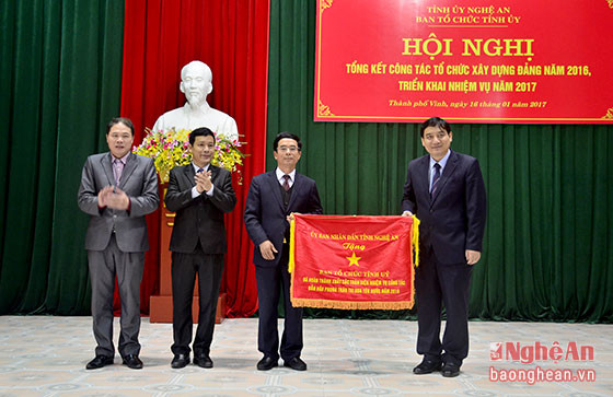 Bí thư Tỉnh ủy Nguyễn Đắc Vinh tặng Cờ thị đua của UBND tỉnh cho Ban Tổ chức Tỉnh ủy. Ảnh Thành Duy