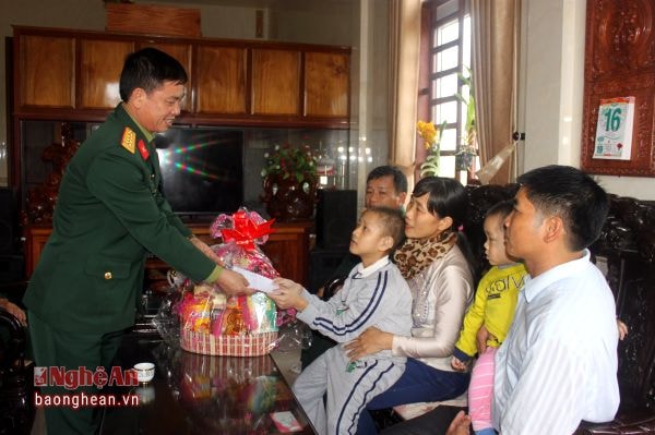 Đại tá Phạm Minh Đức – Chính ủy Cục Hậu cần Quân khu trao quà của Ủy ban Dân số, Gia đình và trẻ em - Quân khu 4  cho cháu Nguyễn Tô Ngọc Khánh     