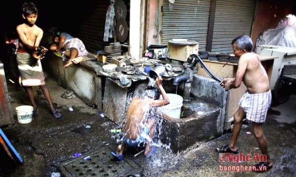 Sự nghèo khổ tại Trung Quốc và Ấn Độ đang ngày càng tồi tệ hơn. Hình ảnh người nhập cư phải tắm bên bể nước công cộng tại New Delhi. Ảnh: theguardian