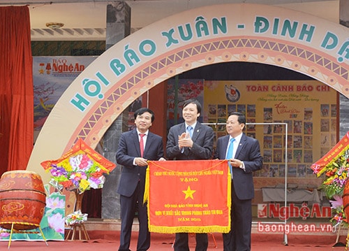 Đồng chí Hồ Quang Lợi - Phó Chủ tịch Thường trực Hội Nhà báo Việt Nam trao cờ thi đua của Chính phủ cho Hội Nhà báo Việt Nam tỉnh Nghệ An. Ảnh: Thu Giang.