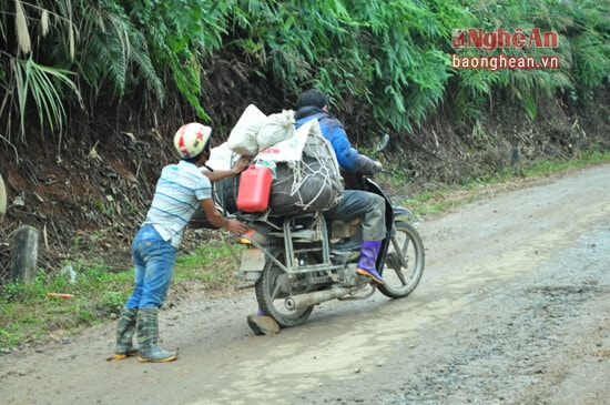 Người dân đi lại chở hàng hóa bằng xe máy cũng phải khó khăn và có người hỗ trợ mới lên được và qua chân dốc