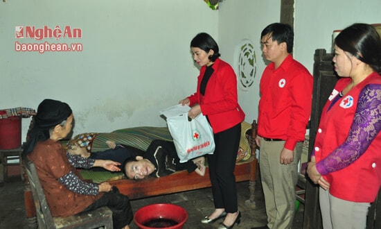 Ngoài trao tiền tài trợ, ủng hộ, đại diện Hội chữ thập đỏ Nghệ An còn trao quà Tết cho các hộ nghèo. Trong ảnh: Bà Nguyễn Lương Hồng trao quà cho hộ bà Trần Thị Nghĩa dưới sự chứng kiến của Hội chữ thập đỏ huyện Anh Sơn và đại diện Chi ủy, ban cán sự xóm 2, xã Tường Sơn 