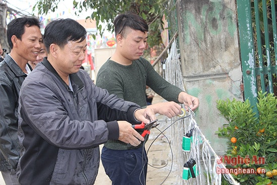 Anh Lê Bá Minh cùng bà con trong tổ liên gia tập trung trang trí đoạn đường chung. Ảnh Hoàng Mai