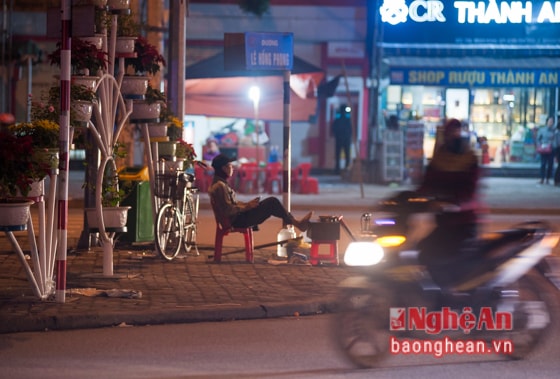 Mặc dù đã muộn nhưng bác thợ sửa xe vẫn kiên nhẫn ngồi đợi khách đi chơi xuân kém may mắn để kiếm thêm.