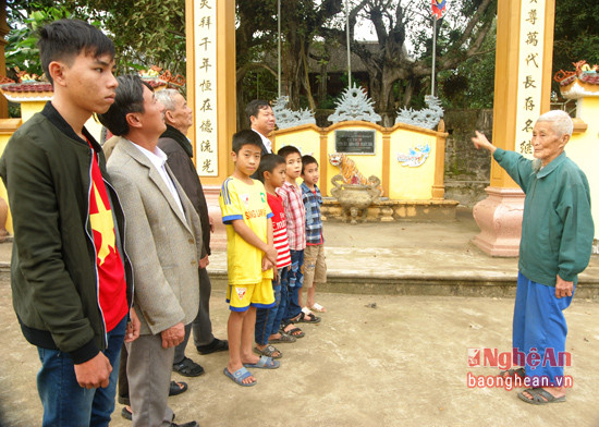 -Cụ Nguyễn Duy Thọ đang giới thiệu lịch sử di tích cho con cháu tại khuôn viên nhà thờ.