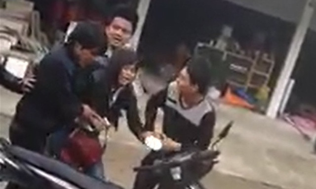 Cô gái bị các thanh niên bắt, ép buộc lên xe máy. Ảnh: Internet. 