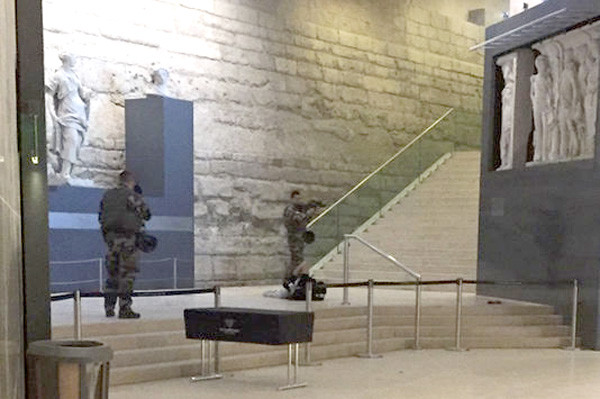 Hai binh lính canh gác một người đàn ông nằm dưới đất sau vụ tấn công bằng dao ở trung tâm mua sắm Carroussel ở Bảo tàng Louvre hôm 3/2. Ảnh: AP
