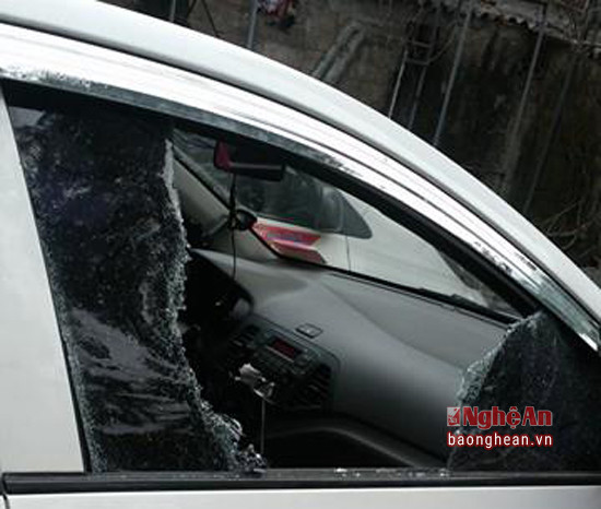 Chiếc xe ô tô của anh Trần Quốc Hoàn dựng ngoài đường bị kẻ gian dùng đá đập vỡ kính trước, trộm camera. Ảnh: Quốc Hoàn