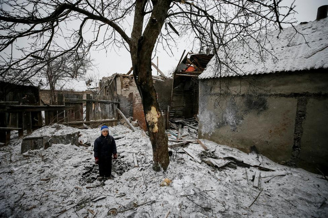 Bé Lesha, 8 tuổi, đứng giữa khu vực bị tàn phá do xung đột ở miền Đông Ukraine. (Ảnh: Reuters)