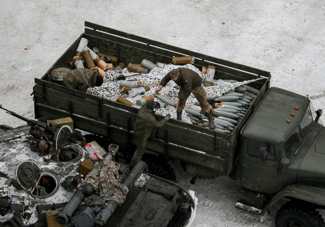 Các thành viên của lực lượng chính phủ Ukraine vận chuyển vũ khí lên xe tăng tại thị trấn Avdiyivka. (Ảnh: Reuters)
