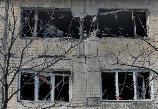 Một người dân địa phương đứng trong ngôi nhà bị tàn phá do chiến sự tại thị trấn Avdiyivka, Ukraine. (Ảnh: Reuters)