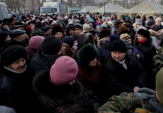 Những người đi sơ tán tập trung tại quầy phát đồ ăn miễn phí tại một trung tâm tạm trú ở thị trấn Avdiyivka. (Ảnh: Reuters)