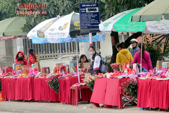 Những quán hàng bán bánh socola và hoa hồng chiếm hết chỗ của điểm dừng xe buýt trước cổng đại học Vinh. Ảnh Nguyên Sơn 
