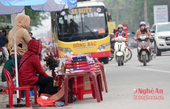 Nhiều người còn bày bán socola, hoa hồng ngay dưới lòng đường, trước làn xe của điểm dừng xe buýt. Ảnh Nguyên Sơn