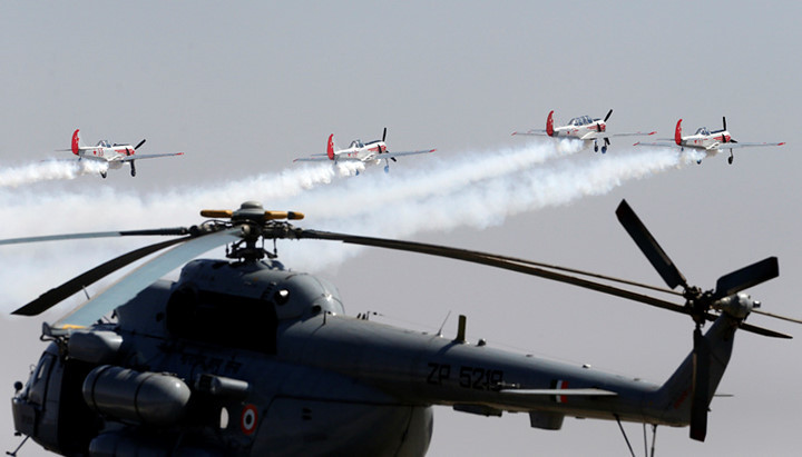 Bốn chiếc máy bay biểu diễn Yakovle của Nga bay phía trước một chiếc trực thăng của Ấn Độ. Ảnh: AP
