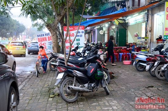 Vỉa hè biến thanh nơi tập kết xe máy, biển hiệu trên đường Nguyễn Văn Cừ. Ảnh: Mỹ Nga