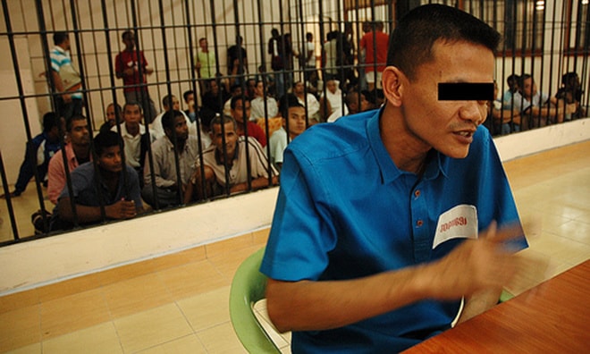 Một tù nhân trả lời các phóng viên báo chí. Những người phía sau đang chờ được trả tự do sau khi mãn hạn tù. Ảnh: Berita Harian Press