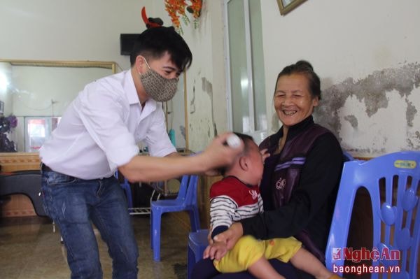Bí thư Chi bộ xóm 13, xã Nghi Thịnh (Nghi Lộc) Lương Văn Tài cắt tóc cho trẻ.