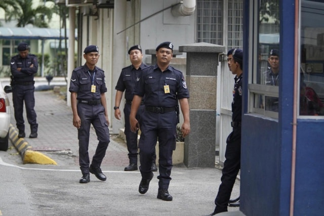 Cảnh sát tuần hành bên ngoài khu giám định pháp y tại bệnh viện Kuala Lumpur, Malaysia. Ảnh: AP