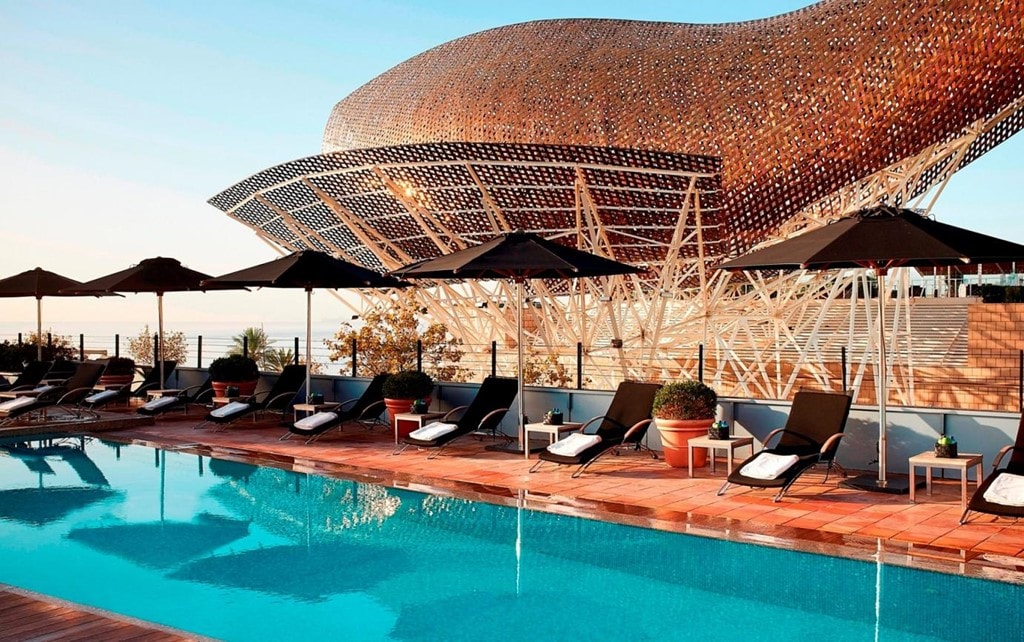 10 bể bơi đẹp nhất thế giới hình ảnh 2 Kiến trúc nổi bật của khách sạn Arts, Barcelona cùng một bể bơi trên sân thượng có tầm nhìn ra biển rất đẹp khiến du khách luôn có cảm giác thư thái khi nghỉ tại đây. Đắm mình trong làn nước, du khách vừa có thể ngắm nhìn biển vừa có thể chiêm ngưỡng tác phẩm điêu khắc độc đáo Peix d’Or (cá vàng) của kiến trúc sư Frank Gehry. Ảnh: Hotelartsbarcelona.
