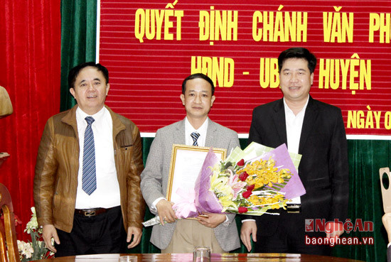 Lãnh đạo huyện Anh Sơn trao Quyết định và tặng hoa chúc mừng đồng chí Nguyễn Quốc Anh.