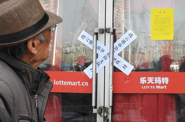 Người đàn ông đứng nhìn cửa hàng Lotte Mart đóng cửa tại Trung Quốc sáng ngày 7/3. Ảnh: GettyNgười đàn ông đứng nhìn cửa hàng Lotte Mart đóng cửa tại Trung Quốc sáng ngày 7/3. Ảnh: Getty