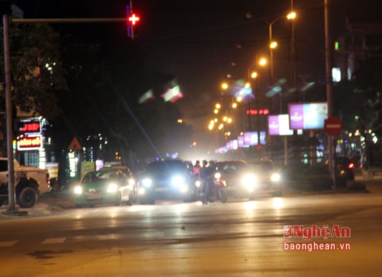 Nhiều xe ô tô đang dừng đèn đỏ nhưng cũng bật đèn pha sáng trưng. Ảnh: Lâm Tùng