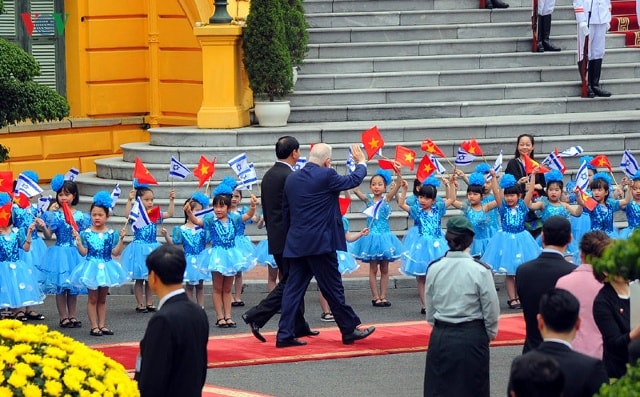 Tổng thống Israel Reuven Ruvi Rivlin vẫy tay chào các em thiếu nhi Việt Nam cầm quốc kỳ Việt Nam, Israel chào đón.