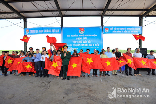 Lãnh đạo Bộ CHQS tỉnh, huyện Diễn Châu và 1 số trường học tặng cờ tổ quốc cho ngư dân xã Diễn Ngọc.