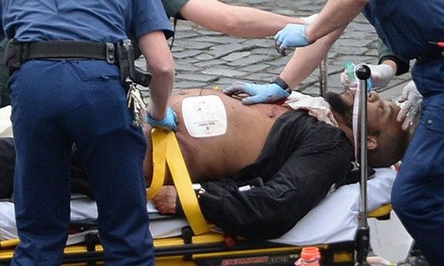 Khalid Masood được cấp cứu nhưng sau đó Khalid Masood lies on a stretcher outside Parliament with paramedics treating his injuries while armed cops stand guard. Ảnh: Reuters