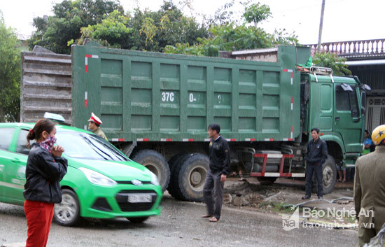 Cách đó chừng 15m là chiếc xe tải chạy ngược chiều nằm quay ngang do va chạm với xe khách.