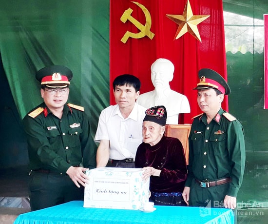 Lãnh đạo Ban CHQS huyện Anh Sơn trao quyết định và quà cho Bà mẹ Việt Nam Anh hùng Hà Thị Đức. Ảnh: Lê Na