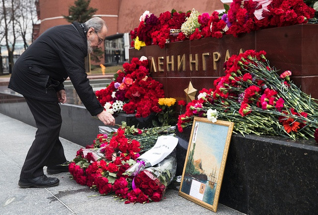 Một người đàn ông đặt hoa tưởng niệm các nạn nhân thiệt mạng trong vụ nổ bom trên tàu điện ngầm ở St. Petersburg. Ảnh: AP.