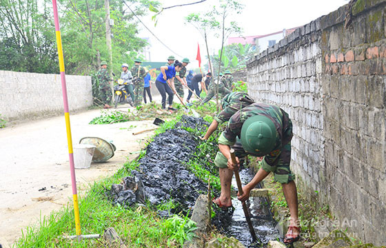 Cán bộ, chiến sỹ Trung đoàn 764 và dân quân tự vệ, đoàn viên xã Nghi Kim giúp nhân dân nạo vét kênh mương. Ảnh: Thành Duy