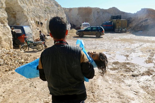 Một người đàn ông mang xác của một đứa trẻ chết, sau khi các nhân viên cứu hộ mô tả như là một cuộc tấn công khí bị nghi ngờ ở thị trấn Khan Sheikhoun trong Idlib, Syria.