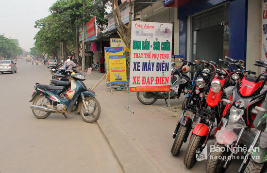 Khách hàng không thể tìm thấy nơi gửi xe, đành phải để giữa lòng đường. Hiệu bán xe máy, xe đạp điện này đã chiếm dụng mất đoạn vỉa hè cho việc kinh doanh của họ.