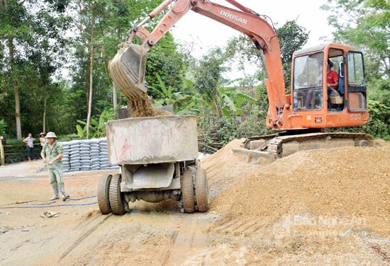 Trộn bê tông làm đường ở xóm Minh Sơn, xã kỳ Sơn, huyện Tân Kỳ. Ảnh: Xuân Hoàng  