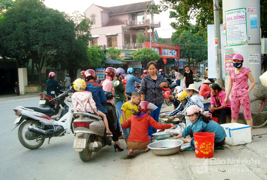 Ngay tại ngã tư thị trấn, dưới cổng chào “huyện Tân Kỳ”, người dân tụ tập, mua bán đông, lúc cao điểm án ngự cả lòng đường bên lề đường. Ảnh: Huy Thư