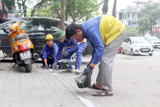 Công ty CP Quản lý đô thị Vinh kẻ vẽ các làn đường cho phép đậu xe trên vỉa hè ở những tuyến rộng trên 3m.Ảnh: Phương Thúy