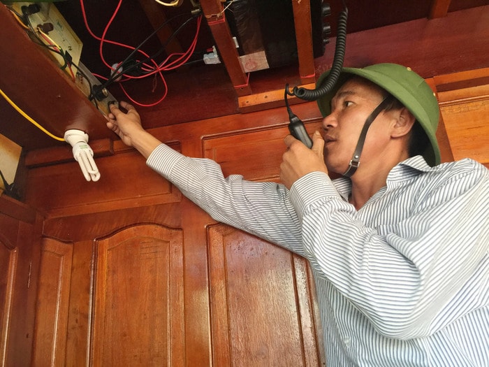 Trên khoang lái, thuyền trưởng Bạch Trọng Vinh đang kết nối  hệ thống Icom với đài Duyên hải Bến Thủy trước khi tàu chuẩn bị xuất bến. Ảnh Nguyễn Vân