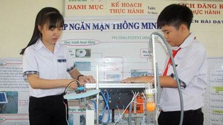 Khánh và Dung lắp đặt thử nghiệm hệ thống đập ngăn mặn thông minh sử dụng năng lượng mặt trời.