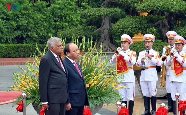 Thủ tướng Nguyễn Xuân Phúc mời Thủ tướng Ranil Wickremesinghe bước lên bục danh dự, quân nhạc cử Quốc thiều hai nước.