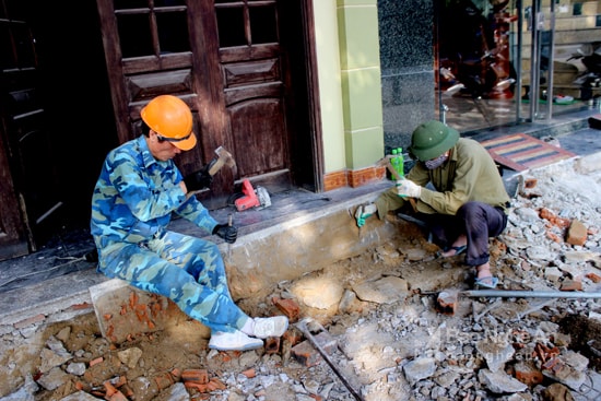 Thợ khoan cắt bê tông, thợ xây vỉa hè. Ảnh: Quang An