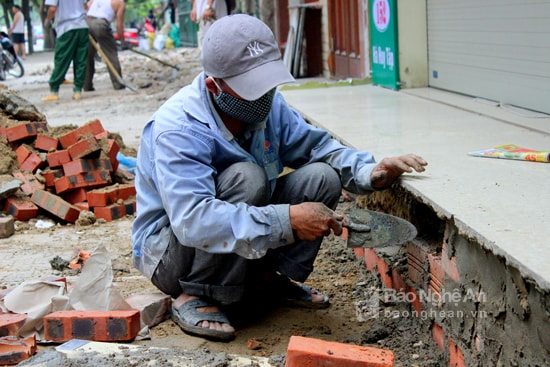 Thợ khoan cắt bê tông, thợ xây vỉa hè. Ảnh: Quang An