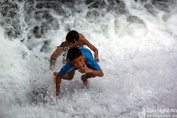 Hai em nhỏ liều lĩnh thi nhau leo ngược dòng, mặc cho nước bắn tung tóe vào người.