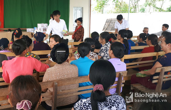 Các nhân viên của Công ty GDVN đang giới thiệu sản phẩm cho bà con ở bản Liên Đình, xã Chi Khê, huyện Con Cuông.