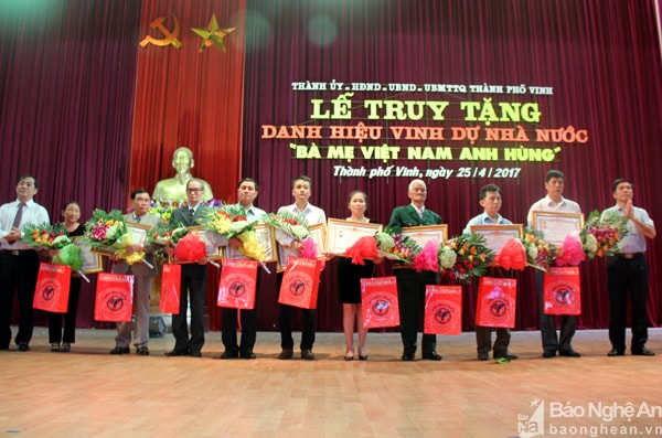 Thân nhân 9 bà mẹ nhận danh hiệu từ lãnh đạo thành phố. Ảnh: Tiến Hùng.