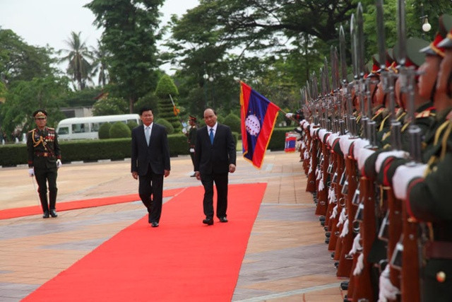 Thủ tướng Thongloun Sisoulith mời Thủ tướng Nguyễn Xuân Phúc duyệt Đội Danh dự.
