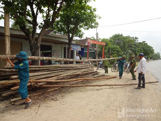 Lực lượng chức năng xã Viên Thành tháo dỡ vật liệu lấn chiếm hành lang trên Quốc lộ 7A. Ảnh: Hồng Nhung